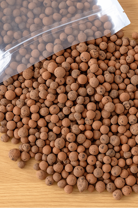 Leca Clay Balls spilling out of a clear plastic bag on a wooden surface