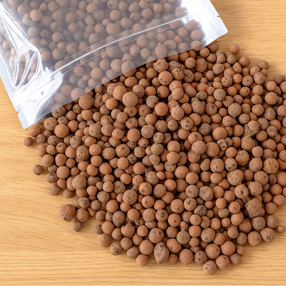 Leca Clay Balls spilling out of a clear plastic bag on a wooden surface