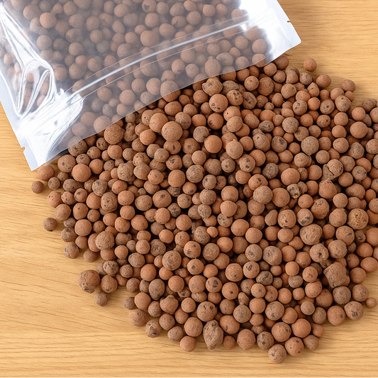 Leca Clay Balls spilling out of a clear plastic bag on a wooden surface